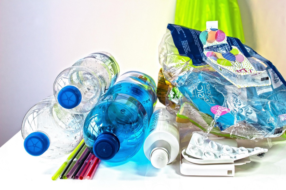 carretera rural con botellas plásticas vacías y basura